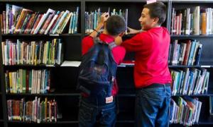 boys looking at books in school
